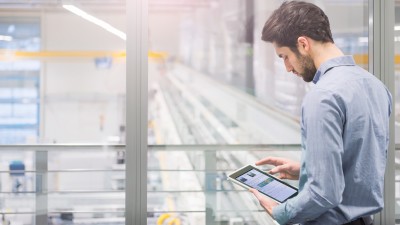Mitarbeiter mit iPad in industrieller Fertigung