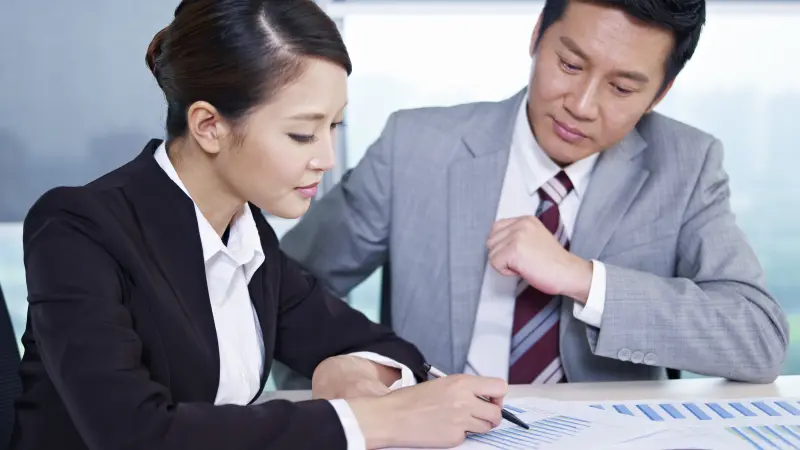 People sitting around a laptop, only their hands are seen